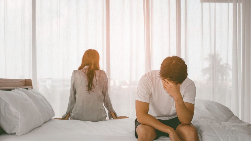 Para siedzi na łóżku odwrócona plecami